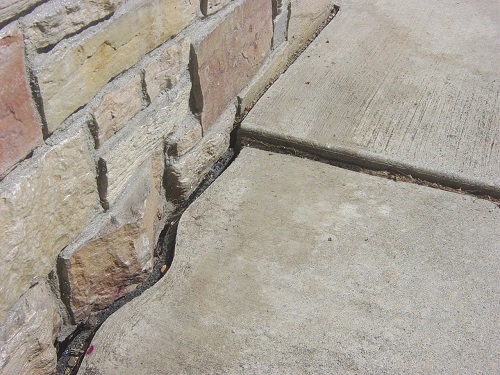 A concrete slab with cracks and some bricks